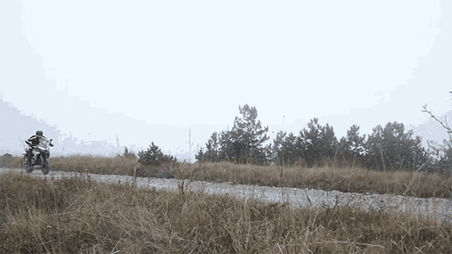 a person is riding a dirt bike down a dirt road