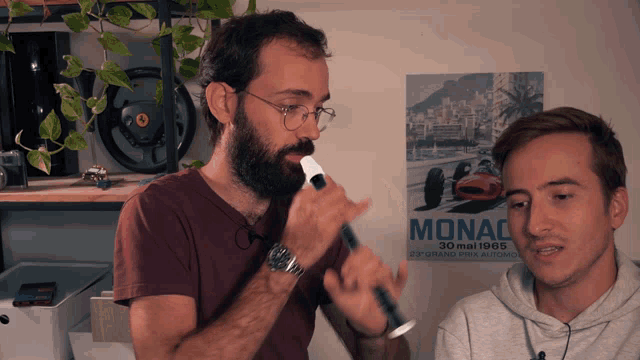 a man playing a flute in front of a poster that says monaco