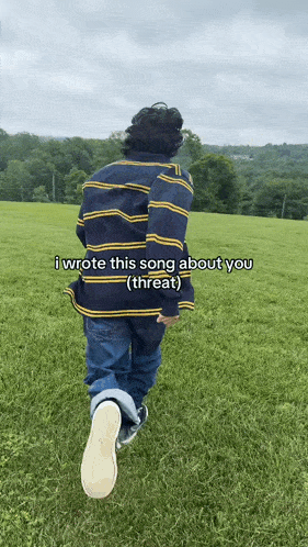 a person in a striped shirt is walking through a grassy field with the caption i wrote this song about you ( threat )