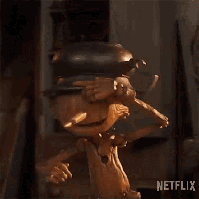 a wooden puppet with a rhino horn is standing on a wooden stick .