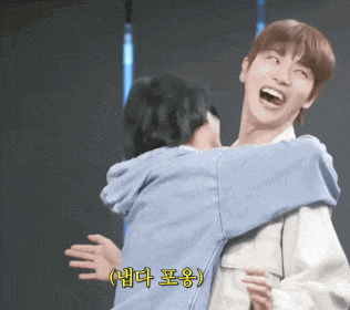 a man is laughing while hugging another man with chinese writing on the bottom