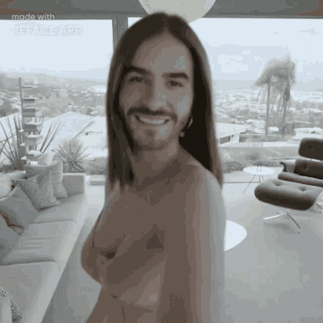 a man with long hair and a beard is standing in a living room