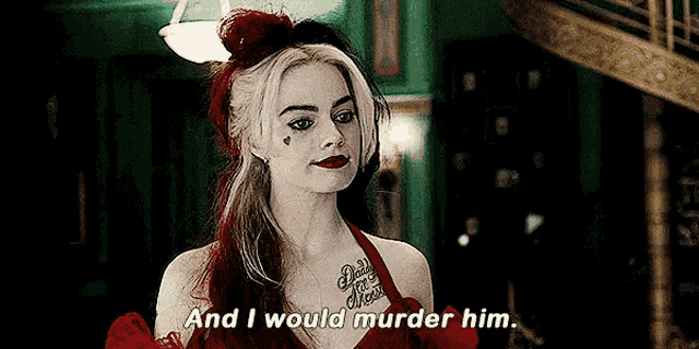 a woman in a red dress with a tattoo on her chest is talking to a man .