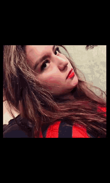 a close up of a woman 's face with long hair and red lipstick