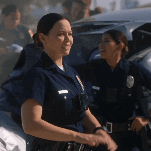 two female police officers standing next to each other with one wearing a name tag that says ' amanda ' on it