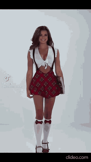 a woman in a school girl costume is standing in front of a white background