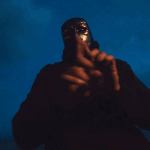a person with a mask on their face is holding a gun