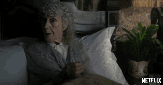an older woman is laying in a bed with a netflix logo in the corner