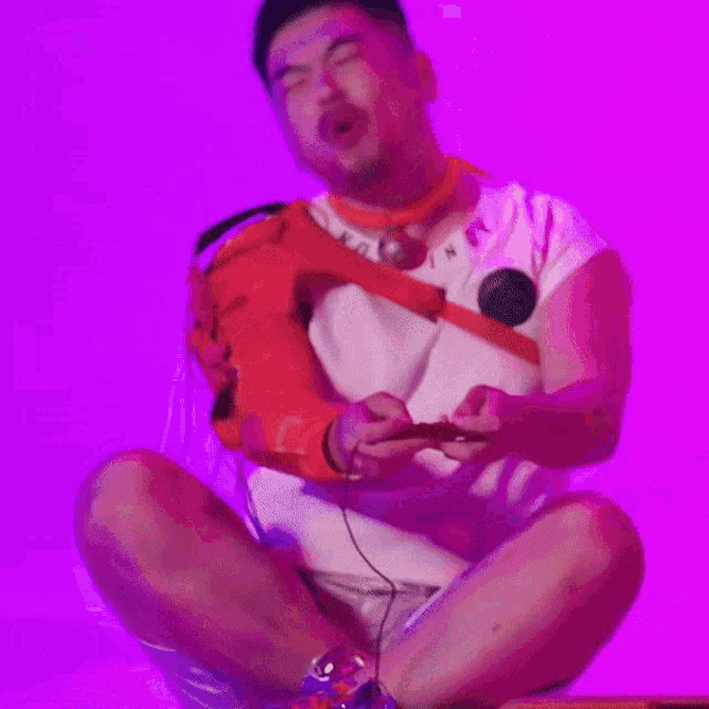 a man wearing a nor n t-shirt sits on the floor