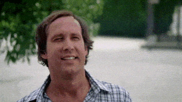 a man wearing a plaid shirt is smiling and looking at the camera