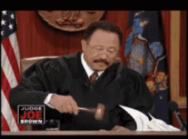 a man in a judge 's robe is holding a gavel in front of a sign that says judge joe brown