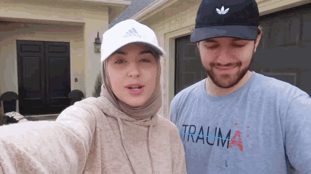 a woman wearing a hijab and a man wearing a t-shirt that says trauma