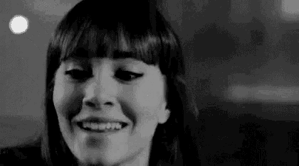 a black and white photo of a woman smiling and laughing .
