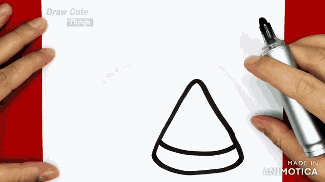 a person is drawing a cone with a marker on a piece of paper that says draw cute things made in animatica