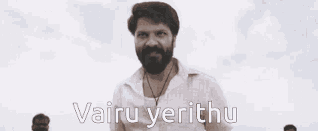 a man with a beard is waving his hand in the air with the words vairu yerithu written below him .