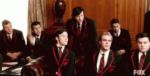 a group of men in suits and ties are sitting in a room with fox written on the bottom of the screen .