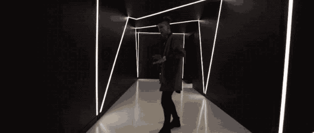 a man in a black jacket is dancing in a dark tunnel