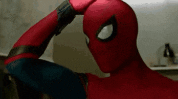 a close up of a person in a spiderman costume holding their hand to their head .