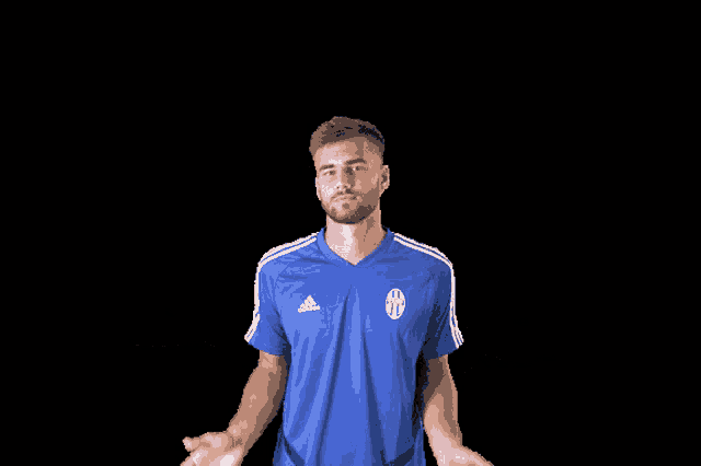 a man wearing a blue adidas shirt is shrugging