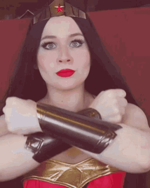 a woman in a wonder woman costume with her arms crossed .