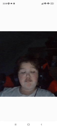 a young boy with a mustache is sitting in a chair with headphones on .