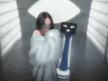a woman in a fur coat stands next to a robot