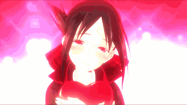 a girl in a red dress is holding a red heart in her hands