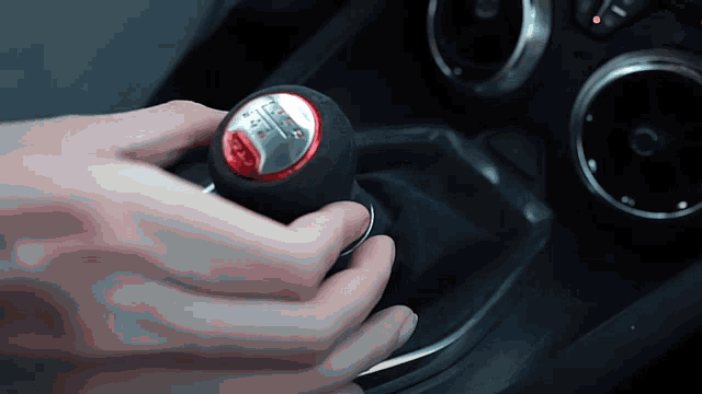 a close up of a person 's hand holding a shift knob with the number 6 on it