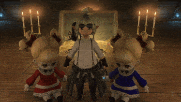 two dolls standing next to a treasure chest with candles in the background