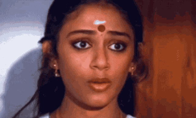 a close up of a woman 's face with a small circle on her forehead