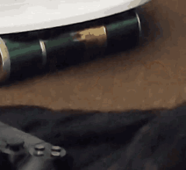 a close up of a video game controller next to a green object