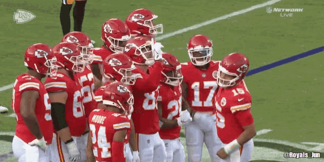 a group of kc football players are huddled together