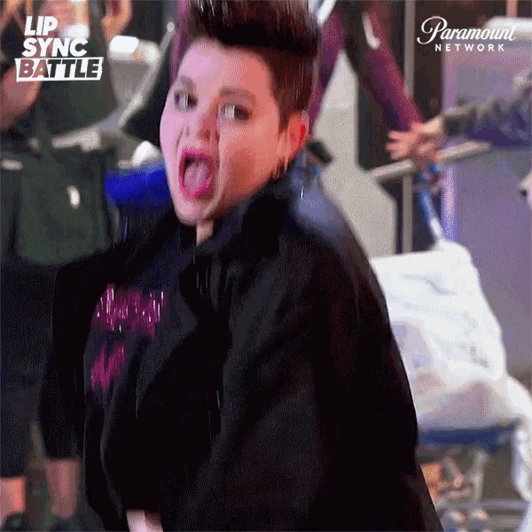 a woman is making a funny face in front of a paramount network ad
