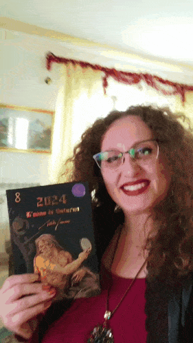 a woman is holding a book that says 2024 on it