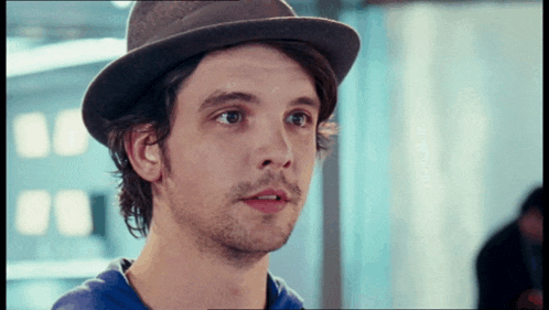 a man wearing a hat and a blue shirt