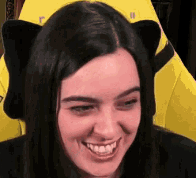 a close up of a woman wearing a cat ear headband and smiling .