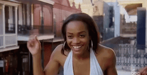 a woman in a white top is smiling and dancing in a street .