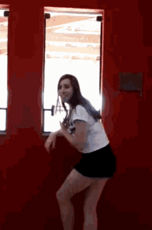 a woman standing in front of a red wall