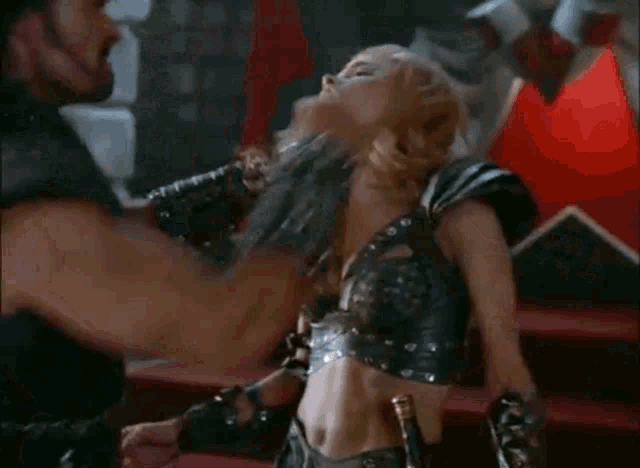 a man is hitting a woman with a sword in a boxing match .