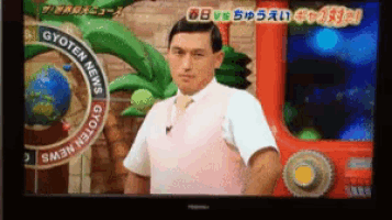 a man in a white shirt and tie is standing in front of a sign that says gyoten news on it