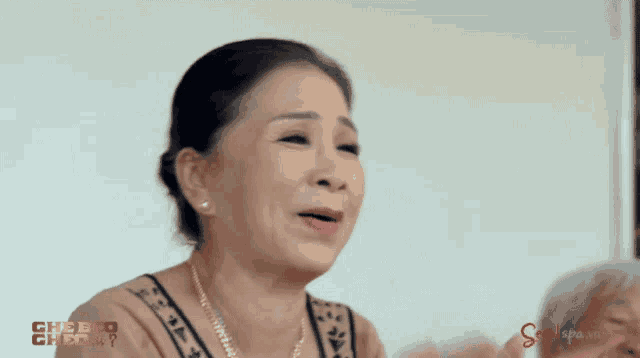 a woman singing in front of a screen that says ' swellspa.vn '