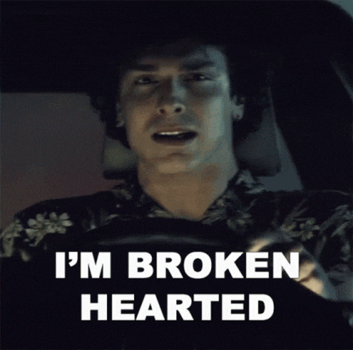 a man sitting in a car with the words i 'm broken hearted