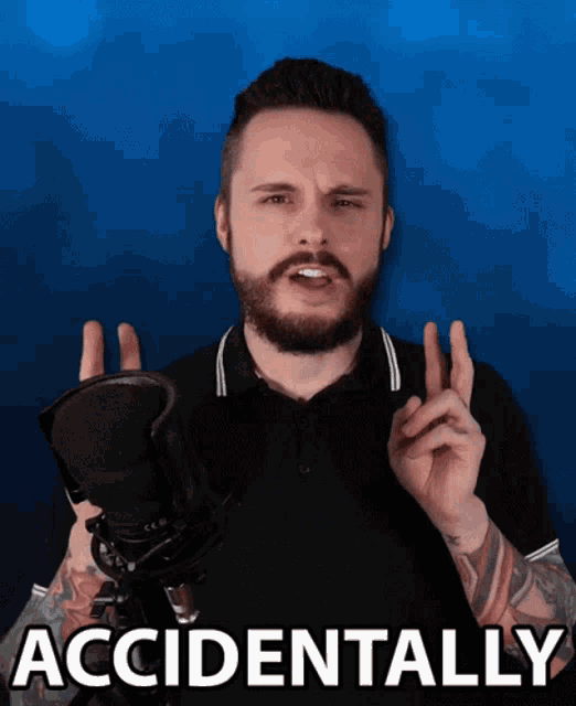a man with a beard is holding a microphone with the words accidentally behind him