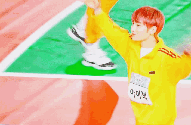 a boy with red hair is wearing a yellow jacket and holding a sign that says ' i am ' on it .