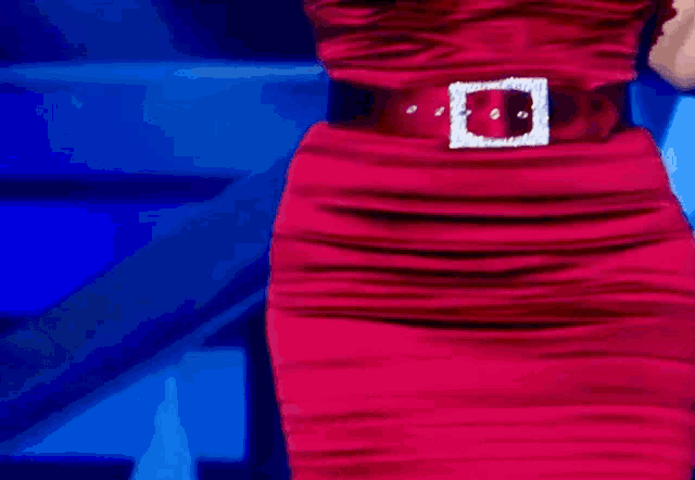 a woman in a red dress with a square buckle on her belt