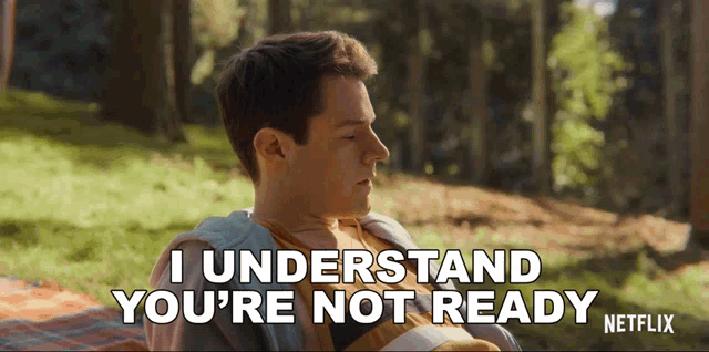 a man is sitting on a blanket in the woods and says " i understand you 're not ready "