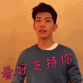a young man wearing a blue sweater with chinese characters on it