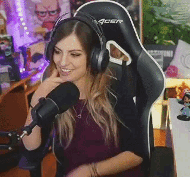 a woman is wearing headphones and sitting in a gaming chair .