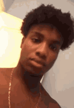 a young man without a shirt is looking at the camera