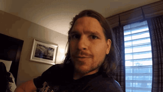 a man with long hair and a beard is wearing a shirt that says ' boston red sox ' on it